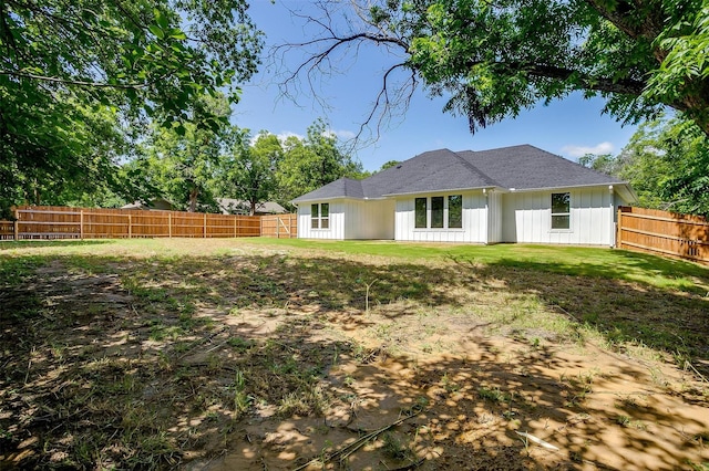 507 S 4th St, Grandview, TX 76050 - back of house with board and batten siding, a fenced backyard, and roof with shingles