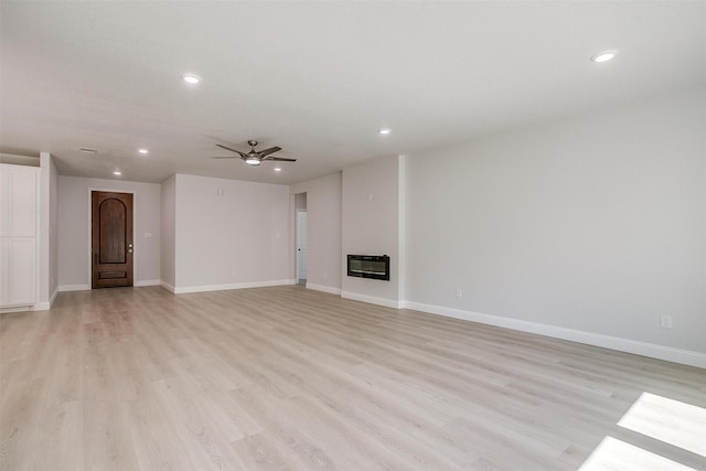 507 S 4th St, Grandview, TX 76050 - unfurnished living room with heating unit, recessed lighting, light wood-style floors, a ceiling fan, and a glass covered fireplace