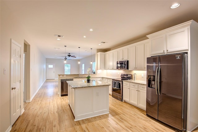 109 W Damon St, Terrell, TX 75160 - kitchen featuring appliances with stainless steel finishes, a peninsula, light wood-type flooring, and recessed lighting