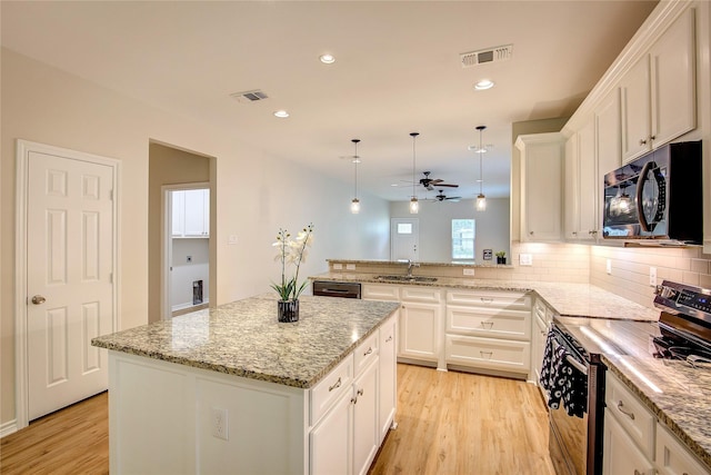 109 W Damon St, Terrell, TX 75160 - kitchen with electric range, light wood-style flooring, a ceiling fan, backsplash, and white cabinetry