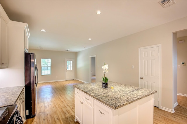 109 W Damon St, Terrell, TX 75160 - kitchen featuring freestanding refrigerator, electric range oven, light wood-type flooring, a kitchen island, and light stone countertops