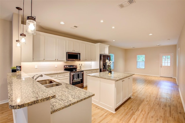 109 W Damon St, Terrell, TX 75160 - kitchen with stainless steel appliances, a center island, backsplash, light wood-style flooring, and recessed lighting
