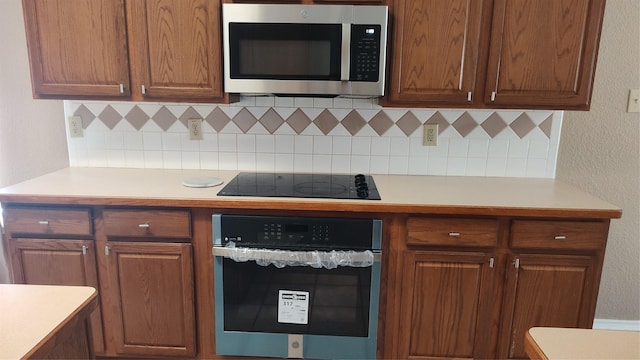 11521 Blanchard Dr, Frisco, TX 75035 - kitchen with stainless steel appliances, light countertops, decorative backsplash, and brown cabinets