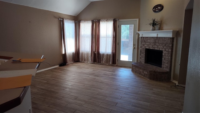 11521 Blanchard Dr, Frisco, TX 75035 - unfurnished living room featuring a fireplace, lofted ceiling, and wood finished floors