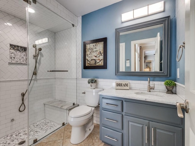 1908 Peninsula Dr, Flower Mound, TX 75022 - bathroom featuring vanity, tiled shower, tile walls, a wainscoted wall, and tile patterned flooring