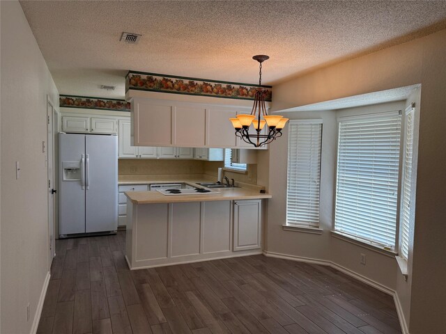 928 Rosebud Dr, Azle, TX 76020 - kitchen with white fridge with ice dispenser, a chandelier, light countertops, white cabinets, and a peninsula