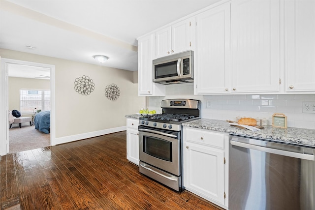 411 Harcourt St, Weatherford, TX 76086 - kitchen featuring appliances with stainless steel finishes, dark wood-style floors, tasteful backsplash, and white cabinets