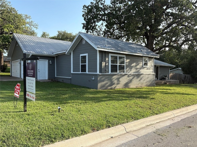 411 Harcourt St, Weatherford, TX 76086 - ranch-style home featuring a garage, brick siding, a front yard, and a metal roof