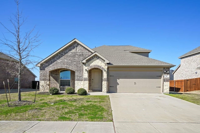 120 Big Bend Dr, Forney, TX 75126 - french provincial home featuring a garage, driveway, roof with shingles, and brick siding