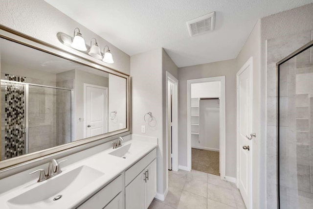 120 Big Bend Dr, Forney, TX 75126 - full bath with a shower stall, double vanity, tile patterned flooring, a spacious closet, and a textured ceiling