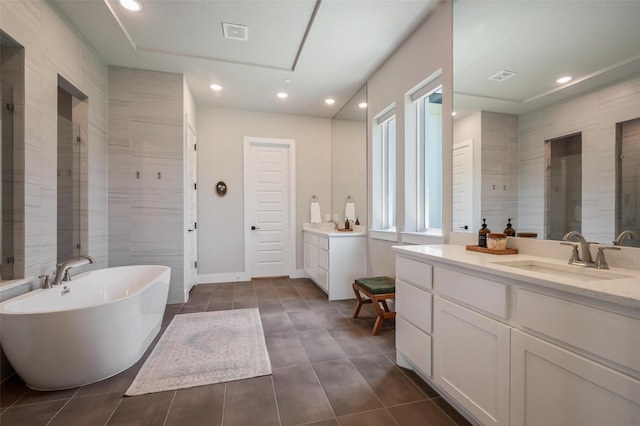 233 Kirkpatrick Ct, Argyle, TX 76226 - bathroom with a freestanding tub, two vanities, tile patterned floors, recessed lighting, and tiled shower