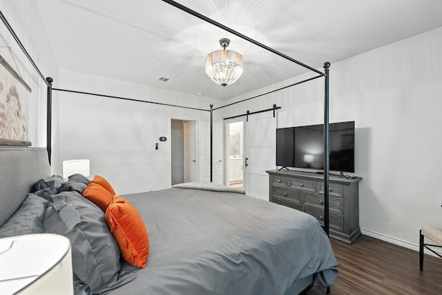 2136 Miramar Dr, Little Elm, TX 75068 - bedroom with dark wood-style floors, a barn door, a chandelier, and connected bathroom