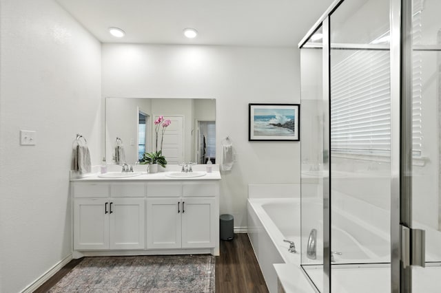 2136 Miramar Dr, Little Elm, TX 75068 - bathroom with double vanity, a garden tub, wood finished floors, and a shower with door