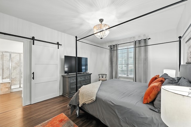 2136 Miramar Dr, Little Elm, TX 75068 - bedroom featuring dark wood finished floors, a barn door, and connected bathroom