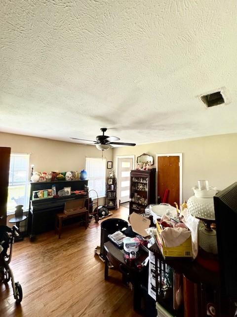 2025 16th St, Garland, TX 75041 - living area featuring ceiling fan, a textured ceiling, and wood finished floors