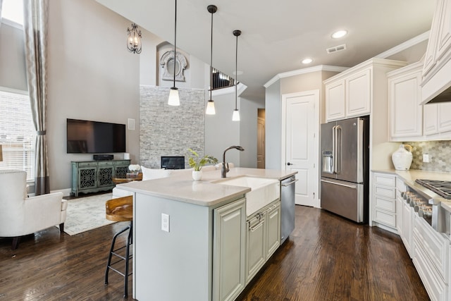 2824 Mastil Rd, Grand Prairie, TX 75054 - kitchen featuring stainless steel appliances, open floor plan, dark wood-style flooring, a kitchen breakfast bar, and a fireplace