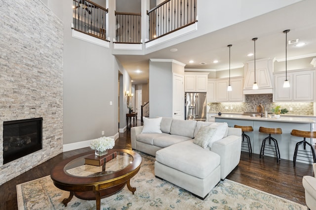 2824 Mastil Rd, Grand Prairie, TX 75054 - living area featuring dark wood-style floors, stairs, a stone fireplace, recessed lighting, and a towering ceiling