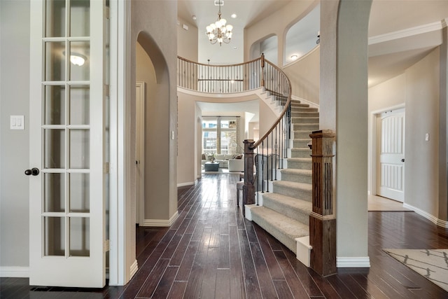 12517 Peace River Dr, Frisco, TX 75035 - foyer with arched walkways, a chandelier, dark wood-style floors, stairs, and a high ceiling