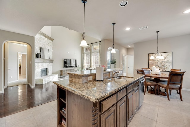12517 Peace River Dr, Frisco, TX 75035 - kitchen featuring light stone counters, an island with sink, light tile patterned floors, dishwasher, and recessed lighting