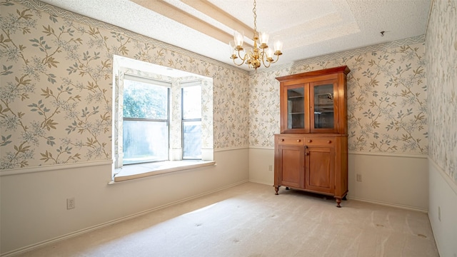 3 Cimarron Dr, Trophy Club, TX 76262 - spare room with a chandelier, a raised ceiling, a textured ceiling, light colored carpet, and a wainscoted wall