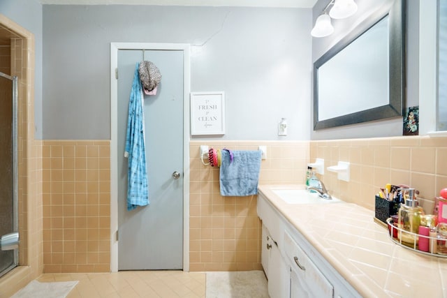 2008 Morningside Dr, Garland, TX 75041 - bathroom with tile walls, a stall shower, vanity, tile patterned floors, and a wainscoted wall