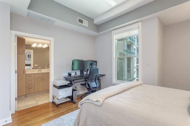 5055 Addison Cir Unit 413, Addison, TX 75001 - bedroom with light wood-type flooring, a chandelier, and ensuite bathroom