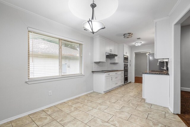 7422 Foxworth Dr, Dallas, TX 75248 - kitchen with under cabinet range hood, stainless steel microwave, white cabinetry, backsplash, and ornamental molding