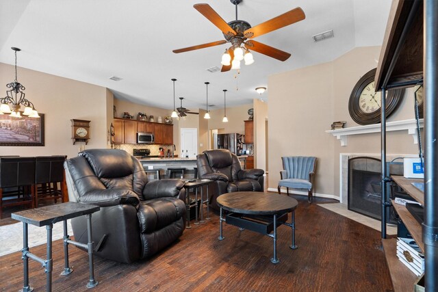 2912 Day Star Dr, Little Elm, TX 75068 - living area with ceiling fan, dark wood-style flooring, a tiled fireplace, and a chandelier
