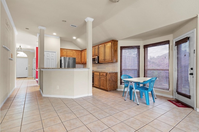 12313 Ark Rd, Frisco, TX 75035 - kitchen with appliances with stainless steel finishes, decorative backsplash, brown cabinets, plenty of natural light, and lofted ceiling