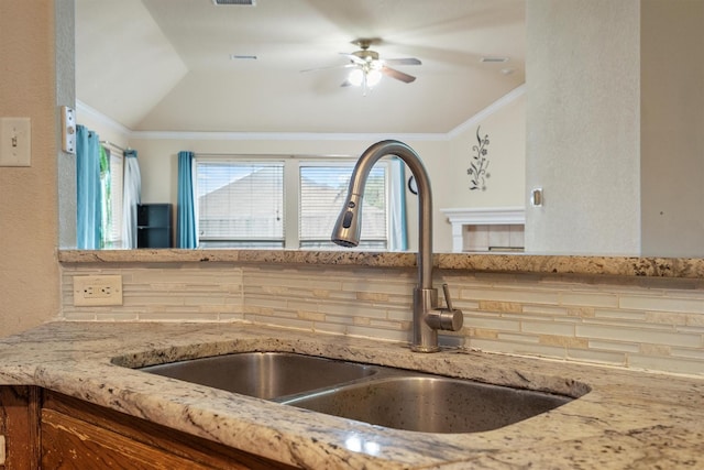 12313 Ark Rd, Frisco, TX 75035 - kitchen view of light stone countertops, ceiling fan, crown molding, and a textured wall
