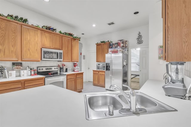 831 Fair Oaks Dr, Grand Prairie, TX 75052 - kitchen featuring stainless steel appliances, light countertops, tasteful backsplash, recessed lighting, and brown cabinets