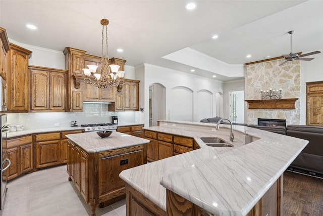 3030 Pecan Grove Ln, Celina, TX 75078 - kitchen with a spacious island, ornamental molding, arched walkways, backsplash, and a fireplace