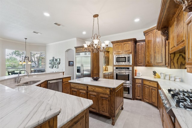 3030 Pecan Grove Ln, Celina, TX 75078 - kitchen featuring built in appliances, a chandelier, a spacious island, ornamental molding, and arched walkways