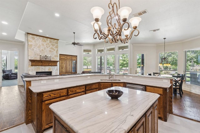 3030 Pecan Grove Ln, Celina, TX 75078 - kitchen featuring a large island, brown cabinetry, a chandelier, plenty of natural light, and crown molding