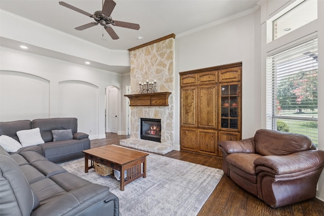 3030 Pecan Grove Ln, Celina, TX 75078 - living area with arched walkways, a ceiling fan, dark wood finished floors, crown molding, and a stone fireplace