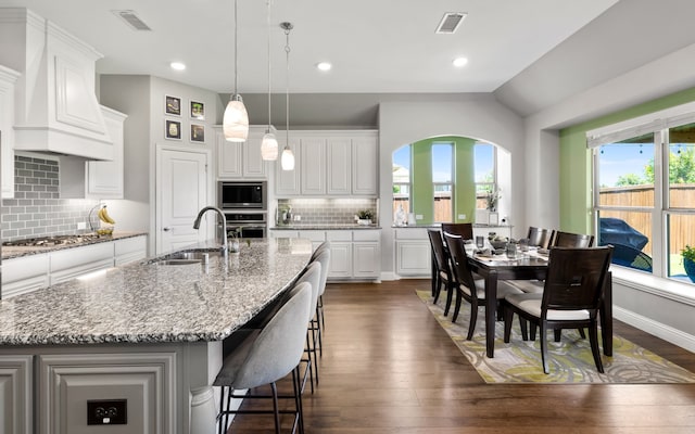 405 Milford, Wylie, TX 75098 - kitchen featuring stainless steel appliances, custom exhaust hood, decorative backsplash, dark wood-type flooring, and white cabinetry