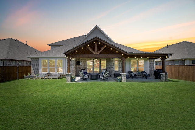405 Milford, Wylie, TX 75098 - back of property at dusk featuring a patio area, a fenced backyard, an outdoor living space with a fire pit, and brick siding