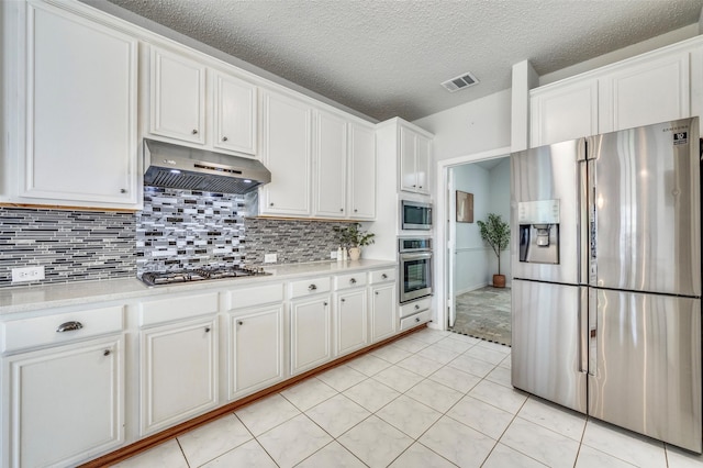 8224 Spring Valley Ln, Plano, TX 75025 - kitchen with appliances with stainless steel finishes, under cabinet range hood, light countertops, white cabinetry, and a textured ceiling