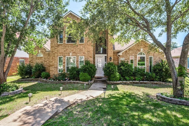 8224 Spring Valley Ln, Plano, TX 75025 - traditional-style house featuring a front yard and brick siding