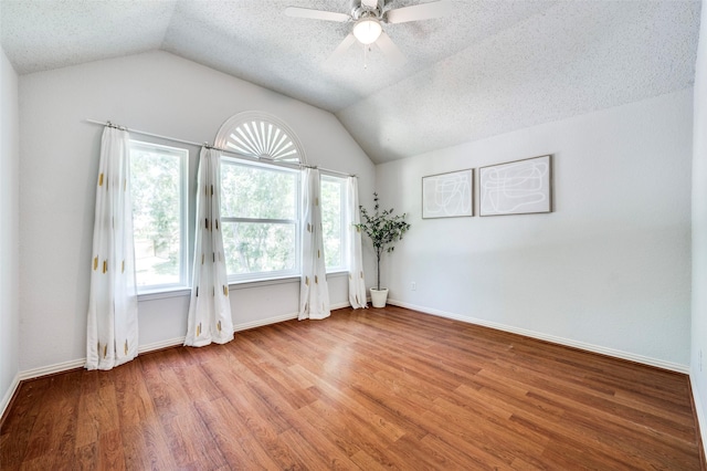 8224 Spring Valley Ln, Plano, TX 75025 - unfurnished room with lofted ceiling, wood finished floors, a ceiling fan, and a textured ceiling