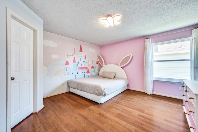 8224 Spring Valley Ln, Plano, TX 75025 - bedroom with light wood finished floors and a textured ceiling