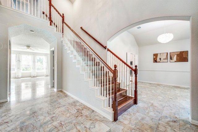 8224 Spring Valley Ln, Plano, TX 75025 - stairway with marble finish flooring, arched walkways, ceiling fan, and high vaulted ceiling