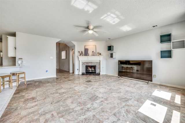 8224 Spring Valley Ln, Plano, TX 75025 - unfurnished living room featuring ceiling fan, a textured ceiling, and a fireplace
