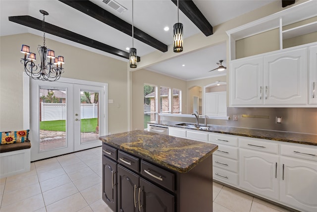5853 Echo Bluff Dr, Haltom City, TX 76137 - kitchen with light tile patterned floors, white cabinets, beamed ceiling, dark stone countertops, and a center island