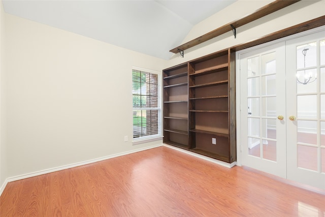 5853 Echo Bluff Dr, Haltom City, TX 76137 - empty room with wood finished floors, vaulted ceiling, a chandelier, and french doors