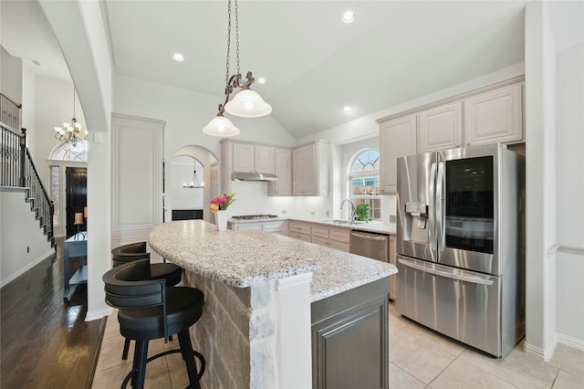 5413 Percy Priest St, Fort Worth, TX 76179 - kitchen featuring stainless steel appliances, a chandelier, a center island, light stone countertops, and vaulted ceiling