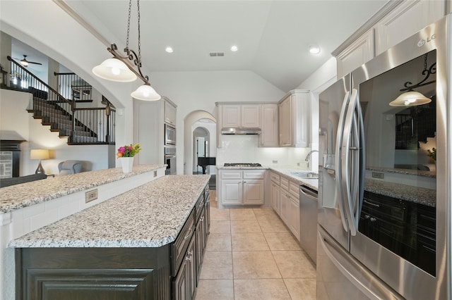 5413 Percy Priest St, Fort Worth, TX 76179 - kitchen with stainless steel appliances, under cabinet range hood, arched walkways, a kitchen island, and light stone countertops