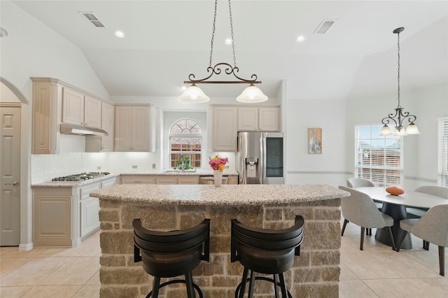 5413 Percy Priest St, Fort Worth, TX 76179 - kitchen with stainless steel appliances, a center island, light tile patterned floors, under cabinet range hood, and tasteful backsplash