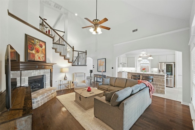 5413 Percy Priest St, Fort Worth, TX 76179 - living area with arched walkways, a fireplace, ceiling fan, high vaulted ceiling, and dark wood-style flooring