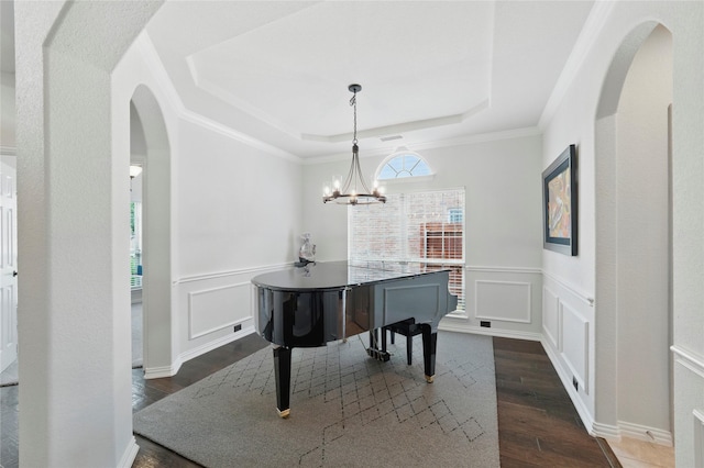 5413 Percy Priest St, Fort Worth, TX 76179 - dining room featuring a raised ceiling, dark wood-style flooring, a chandelier, arched walkways, and wainscoting